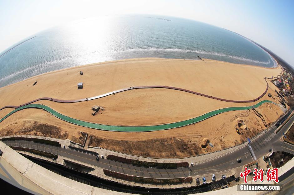 3月13日，秦皇島萬米臨海沙灘木棧道。據(jù)了解，該木棧道全長約4200米，與北戴河區(qū)原有的7500米木棧道對接后全線總長度1.17萬米，整個木棧道東起秦皇島體育基地游船碼頭，西至北戴河濕地公園，呈波浪形蜿蜒10.4公里海岸線。 中新社發(fā) 曹建雄 攝 CNSPHOTO